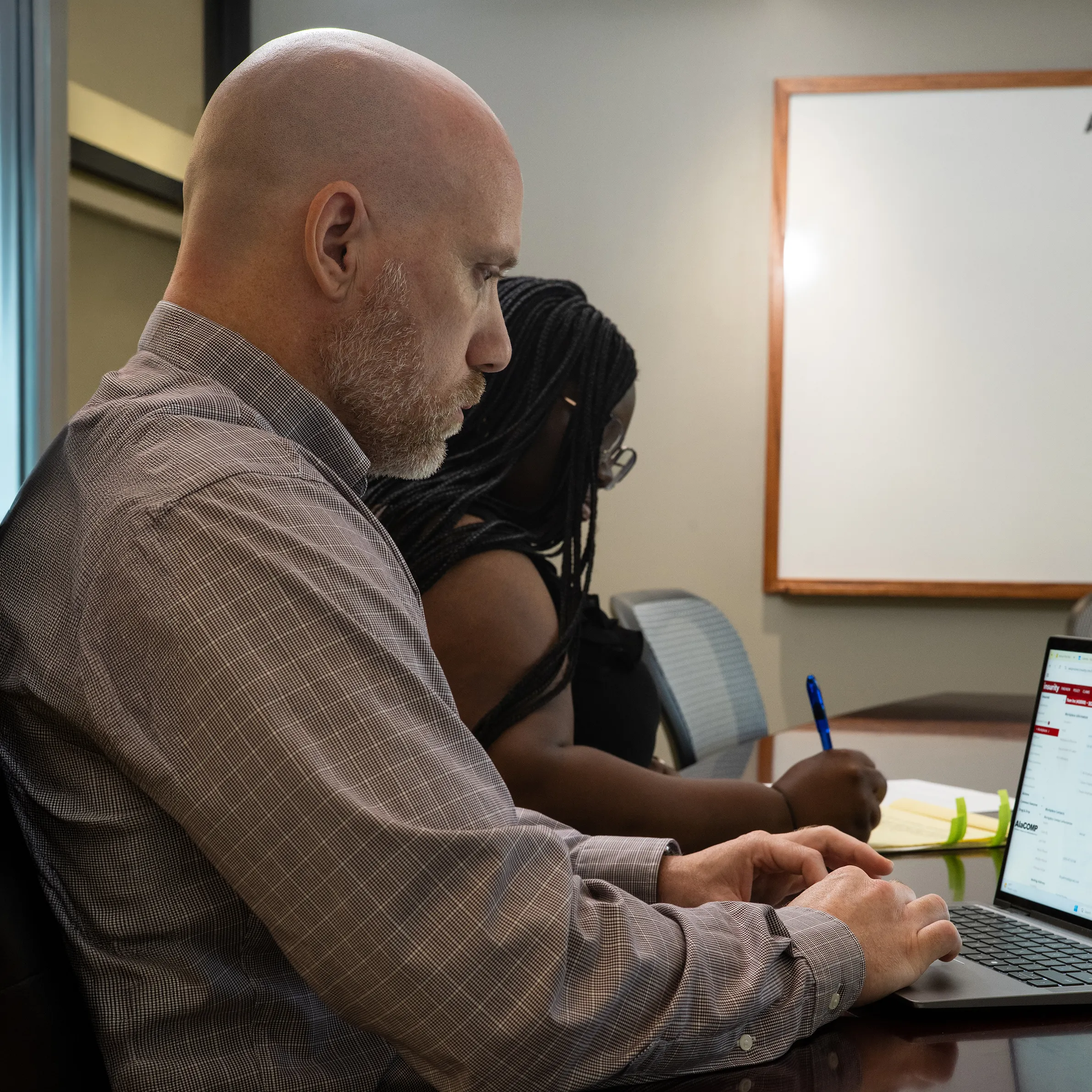 AlaCOMP team members reviewing workers’ compensation information during a meeting.